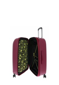Valise rigide bordeaux ouverte pour montrer un intérieur noir avec des icônes de voyage jaunes et des sangles réglables, se tenant sur quatre roues.