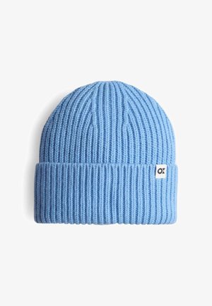 Cappellino beanie azzurro chiaro lavorato a maglia con texture a coste, orlo ripiegato e piccola etichetta bianca con logo nero sul lato.