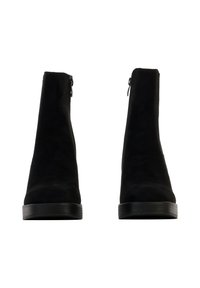 Bottines en daim noir à texture lisse, dotées d'une fermeture éclair latérale et d'une semelle noire robuste. Le design est simple et épuré.