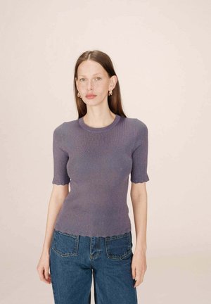 Haut en tricot côtelé violet à manches courtes, à ourlet festonné et à silhouette moulante, associé à un jean en denim taille haute.