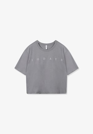 Camiseta gris recortada con mangas cortas, cuello redondo y el texto "1 0 D A Y S" impreso en blanco en el frente. Textura de tela suave.