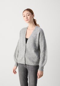Cardigan grigio lavorato a maglia con scollo a V, maniche lunghe e voluminose, e chiusura con bottoni. Texture morbida, vestibilità ampia e motivo a coste lungo i polsini e la vita.