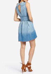 Sukienka dżinsowa w jasnym niebieskim kolorze, z dopasowaną talią, plisowanym dołem i odsłoniętymi plecami. Posiada niedokończony brzeg z różowymi akcentami.