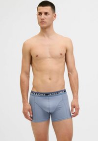 Világoskék boxeralakú alsónemű, sötétkék derékrésszel, melyen a "JACK & JONES" logó látható. Sima textúra, testhezálló forma és kontrasztos varrási részletek.