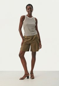 Gestreiftes Tanktop in Beige und Braun, kombiniert mit olivgrünen Shorts. Das Outfit bietet eine lässige Passform und leichte Stoffe. Schwarze, blockierte Sandalen.