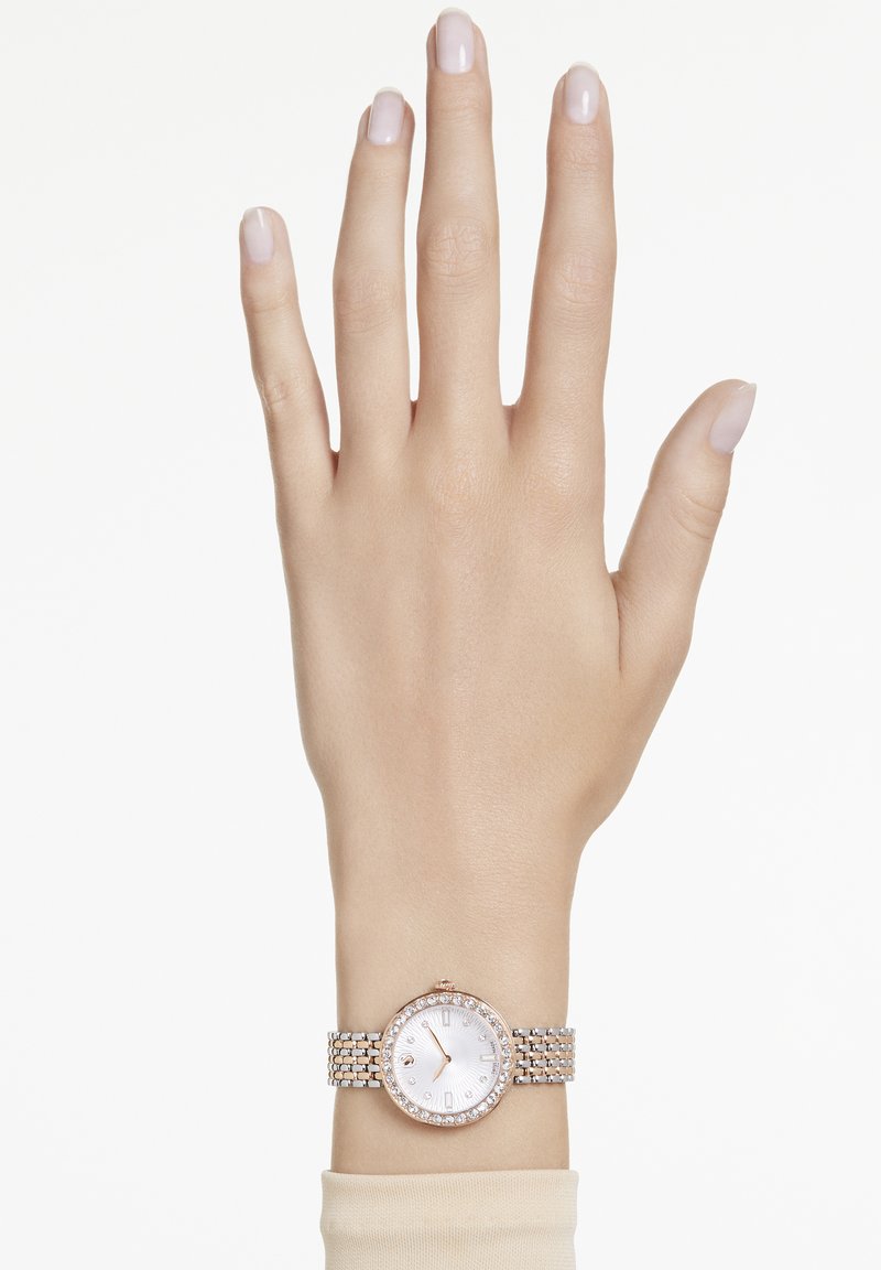 Rund ur med rosaguld sag og diamanter som accent på et sølv mesh rem; hvid urskive med enkle time markører og visere.
