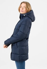 Navy blue puffer jacket with a hood, featuring a quilted design, side pockets, and drawstring accents. Soft texture and warm insulation.