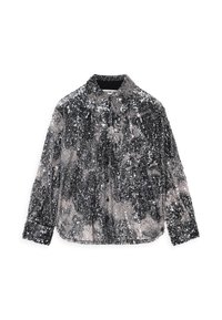 Chemise pailletée en argent et noir, avec un col et des manches longues. La surface est ornée de paillettes brillantes et réfléchissantes de tailles variées.