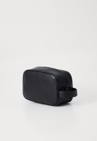 Necesar din piele neagră, cu formă rectangulară, închidere cu fermoar și mână laterală. Textură netedă cu margini ușor rotunjite.