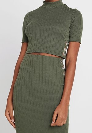 Short-sleeve olive green ribbed crop top and matching high-waist skirt with button details on sides.