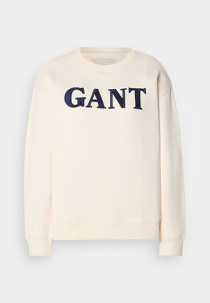 Cremefarbenes Sweatshirt mit Rundhalsausschnitt, gerippten Bündchen und einem großen navyblauen gestickten "GANT"-Logo auf der Vorderseite.