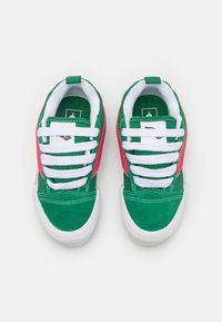 Grüne Canvas-Sneakers mit pinken Akzenten, weißen Schnürsenkeln und Gummisohlen. Mit gepolsterter Kante und Zunge, texturiertem Obermaterial.