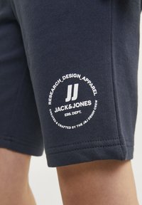 Marina shorts gjorda av en bomullsblandning med vit textlogotyp och cirkulärt mönster. Slät textur med sydda kanter och sidofickor.