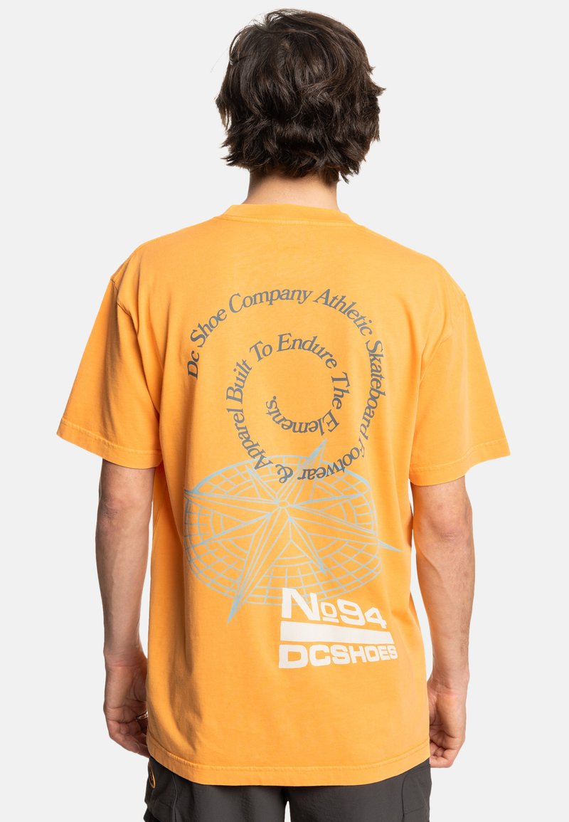 Orange cotton t-shirt with short sleeves, featuring a graphic on the back with text and a compass design in gray.