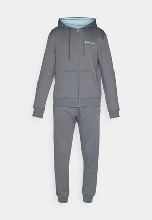 Hallitseva halli tõmblukk hoodie, millel on hele sinine sisemus ja ees olevad taskud, koos sobivate hallide dressipükstega, millel on sääreotsad ja logosilmad.