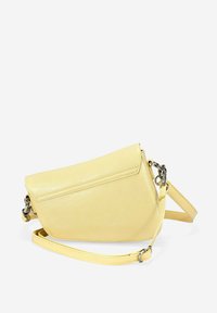 Bolso de cuero amarillo con forma triangular, cierre de solapa y correa de hombro ajustable. Presenta detalles de hardware metálico.