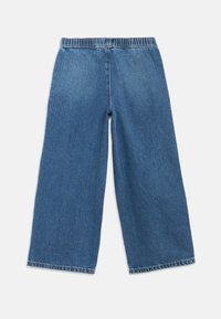 Calças de ganga de perna larga em azul médio, com cintura elástica, bainha sem acabamento e textura suave. Design simples e sem adornos.