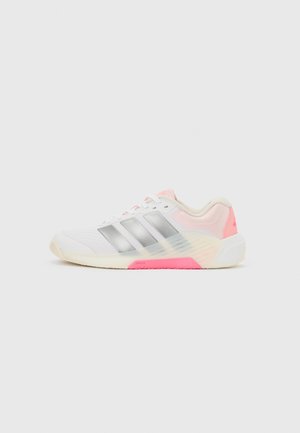 Chaussure de sport blanche avec des rayures argentées, des accents rose clair et une semelle translucide avec une section rose vif près du talon.