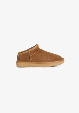 Scarpa in suede marrone slip-on con punta arrotondata, collo imbottito e suola in gomma con motivo a grip testurizzato.