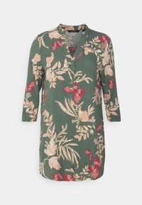 Blumen-Tunikashirt aus grünem Stoff mit pinken Blumen und roten Schmetterlingen; V-Ausschnitt-Design mit Dreiviertelärmeln und einem lässigen Schnitt.