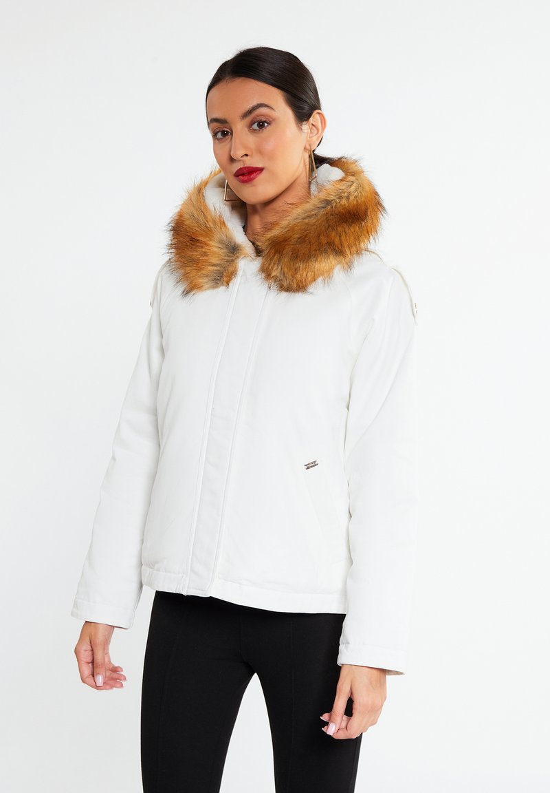 Hvid jakke med en faux fur hætte, der har orange-brune detaljer, lynlås lukning og sidelommer. Glat tekstur med et let pouffet design.
