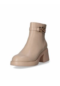 Stivaletto beige realizzato in pelle liscia, con punta rotonda, tacco largo e una fascia decorativa con fibbia attorno alla caviglia.