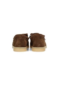 Mocasines de ante marrón con puntera redondeada, que presentan acentos trenzados y una suela de goma beige flexible. La vista trasera muestra los cordones y los detalles de costura.