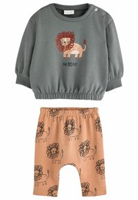 Grå sweatshirt med løvegrafik og teksten "Vær modig"; parret med ferskenfarvede shorts med et gentaget mønster af løver og blomster.