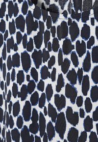 Raštuota medžiaga su tamsiai mėlynu ir baltu leopardų raštu. Tekstūra atrodo lygi, su apvaliais, netaisyklingais raštais visur.