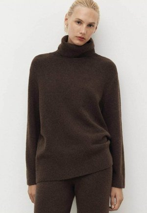 Brown turtleneck sweater in soft knit material, featuring a relaxed fit and long sleeves. Sweater has a subtle texture and draped hemline.