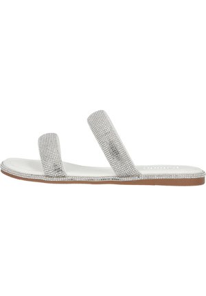 Silver slide sandals with two wide straps adorned with rhinestones, smooth white footbed, and a flat tan sole.