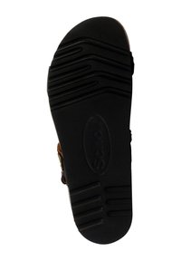 Suela de zapato de goma negra con un patrón texturizado y acanalado. Cuenta con un logotipo circular en el centro y un borde exterior liso. Diseño de punta redondeada.