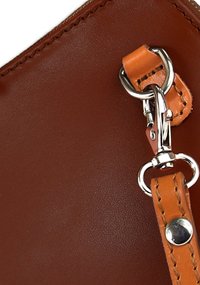 Bruine leren tas met een gladde textuur, voorzien van een lichtbruine riem en zilverkleurige hardware, waaronder een gesp en ringdetail.