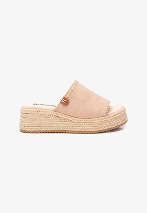 Sandalia de cuña beige con parte superior de cuero suave, plantilla de yute trenzado y un pequeño logotipo en el lateral. Suela de goma texturizada.