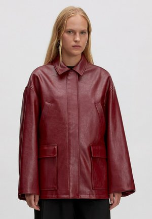 Rode faux leren jas met een kraag, oversized pasvorm, twee voorzakken en een gladde textuur. Minimalistisch ontwerp zonder versieringen.