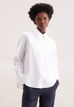 Camicia bianca con bottoni, realizzata in morbido tessuto di cotone, caratterizzata da un colletto classico, maniche lunghe e un orlo dritto. Adatta per occasioni formali e casual.