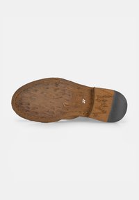 Sole di scarpa in pelle marrone con texture visibile, cuciture chiare e tacco in gomma nera. Taglia contrassegnata come 37.