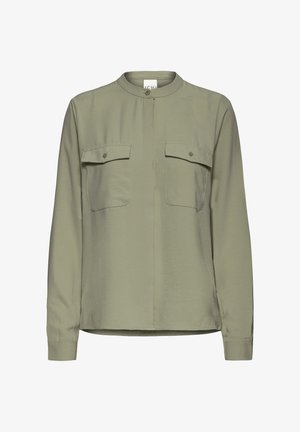 Žalia ilgomis rankovėmis marškiniai su mandarinų apykakle, dviem krūtinės kišenėmis ir lygiu, šiek tiek blizgiu audinio paviršiumi.