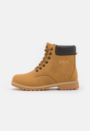 Brun snørestøvle til anklen med polstret sort krave, robust sål og FILA-logo på siden, vist i højre profil på hvid baggrund.