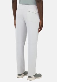 Light grey athletic pants with an elastic waistband, featuring a single back pocket and contrast stitching along the seams.