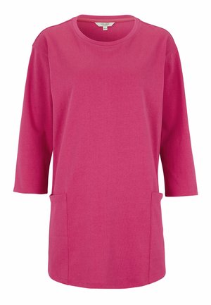 Felroze tuniek met lange mouwen, ronde halslijn, twee voorzakken en een rechte zoom.