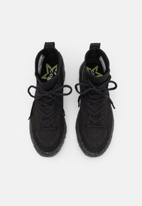 Zwarte gebreide high-top sneakers met ronde veters, een gestructureerd oppervlak en een rubberen zool, met een felgroen logo op de inlegzool.