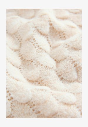 Tissu blanc en maille avec une texture douce et duveteuse présentant un motif ondulé et des fils dorés subtils tissés partout.