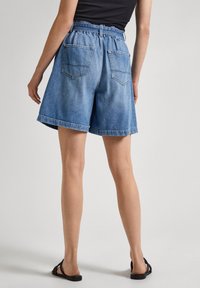 Ljusblå jeansshorts med en avslappnad passform, hög midja, fyra fickor och uppvikt fålldesign.