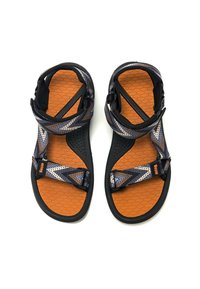 Chanclas negras y naranjas con una plantilla texturizada en forma de panal. Cuentan con correas ajustables con un patrón y un cierre seguro para un buen ajuste.