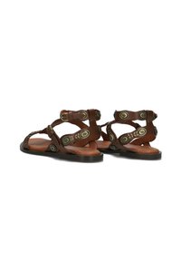 Bruine leren sandalen met meerdere banden, ronde metalen accenten en een platte zool. Het open ontwerp zorgt voor ademend vermogen.