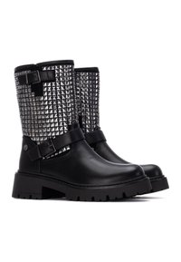 Botas de tobillo de cuero negro con un eje cubierto de brillantes tachuelas piramidales plateadas, con una suela gruesa negra y correas ajustables para un mejor ajuste.