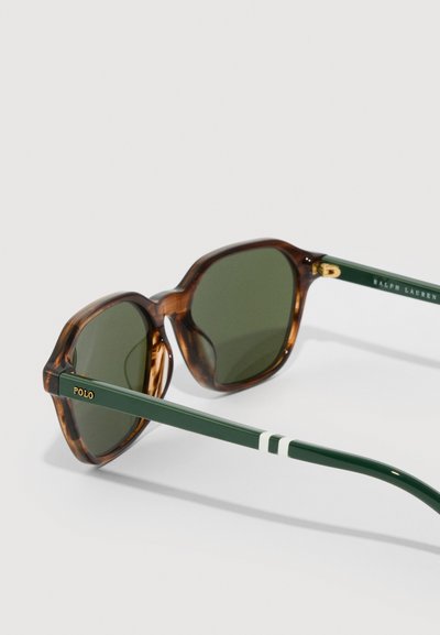Ochelari de soare rotunzi din scoică cu lentile verde închis și brațe verde închis, având dungi albe și logo-uri aurii "Polo" și "Ralph Lauren".