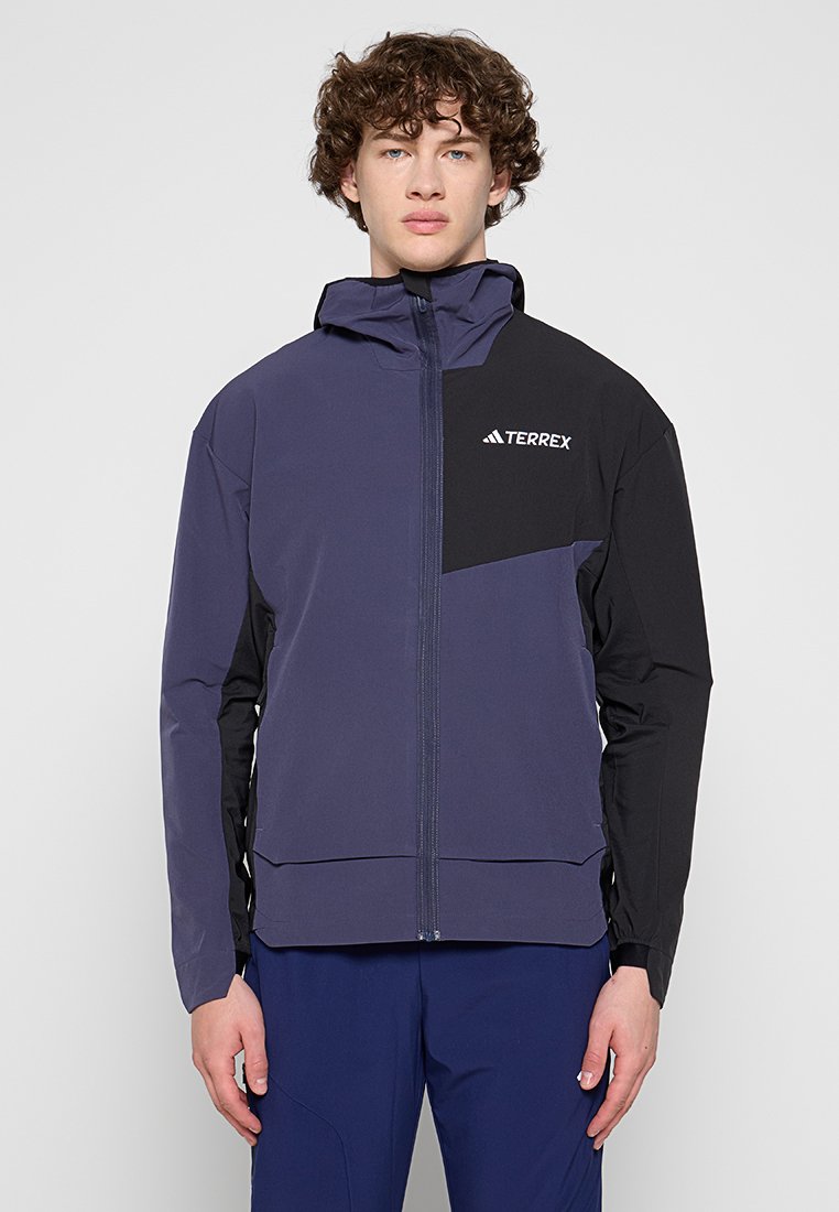 Chaqueta Terrex para hombre con un diseño de color bloque en púrpura y negro, con cierre de cremallera frontal, capucha y logo en el pecho. Fabricada en material ligero.