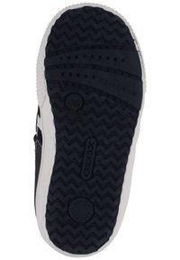 Suela de zapato de goma negra con un patrón texturizado en zigzag, que presenta marcas de la marca "GEOX", "SISTEMA FLEXY" y "SUAVEMENTE AMORTIGUADO" en relieve.